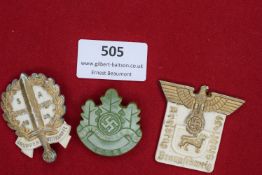 A group of three German day/event badges, comprising: an S.A. Gruppen Wettkämpfe 1939 badge in white