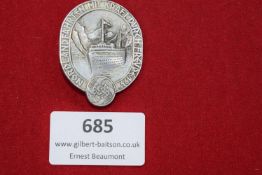 Aluminium badge depicting a cruise liner before mountains, inscribed 