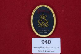 An oval fabric badge with embroidered gilt crowned monogram on black ground, inscribed 153 Jubiläums