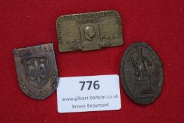 A group of three assorted commemorative tinnies, including: a WWI veterans’ badge for the 2nd Army