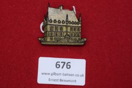 A stamped and gilt WHW donation badge in the form of the Rathaus Osnabrück. Inscribed to reverse “