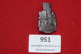 A pressed tin day badge depicting the ruins of Trifels Castle at Annweiler, with legend “P.F.W.