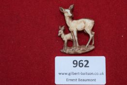 A delicate brooch in the form of a doe and fawn, finely carved from composite or early plastic