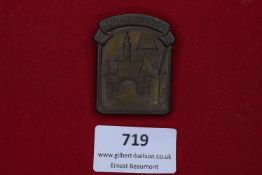 Bronze-coloured rectangular badge with arched top, depicting city gate of Rothenburg ob der