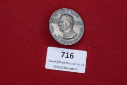 A circular Third Reich badge with bust of Adolf Hitler, inscribed Hitler’s Dank – Für den Dienst