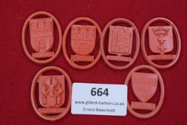 Six oval-framed celluloid/plastic badges, each with a city coat of arms including Krakau, Posen,