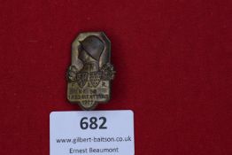 A bronze finish badge for the 59th Field Artillery Regiment, featuring a steel helmet profile