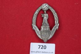 A pair of oval badges each depicting a statue above city arms, flanked by oak leaves and