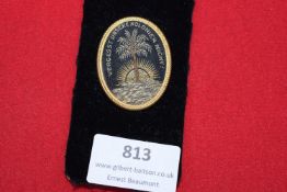 German embroidered badge, oval form with gilt edge, showing palm tree and rising sun, inscribed 