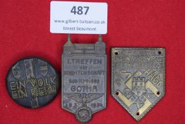 Three badges: a circular bronze-finish badge with shields and legend Ein Volk, Ein Reich; a