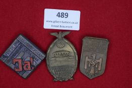 A group of three Third Reich period badges in coloured pressed fibre. Comprising: a 1937 badge