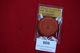 A rare surviving example of a wartime German police vehicle pass disc, constructed of pressed red