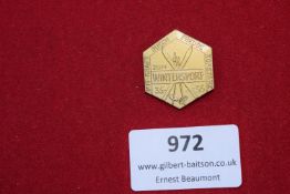 A gilded hexagonal badge inscribed 