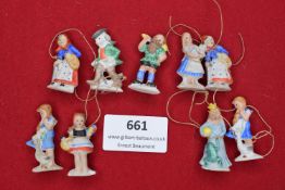 A charming set of 9 small painted porcelain figures issued by the WHW, depicting men, women, and