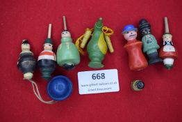 A collection of eight brightly painted wooden novelty figures, including human forms and an