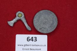 Pair of Badges – Shield and Axe Motif Comprising two metal badges: one circular with impressed