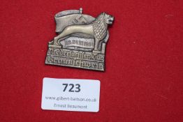 A badge in the form of a lion standing before a flag with swastika, inscribed “23/24 VI 1934