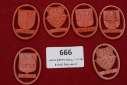 A selection of six red celluloid day badges, depicting the crests of Metz, Eger (two examples),