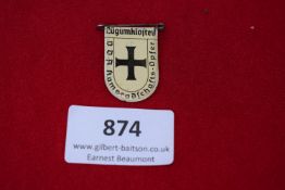 Lügumkloster VDA Tinnie, a pressed-tin badge with cream enamel ground and black cross, inscribed VDA