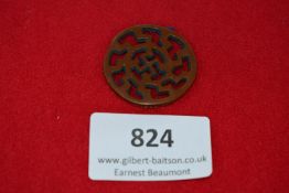 Winterhilfswerk Badge, a brown Bakelite badge cut with stylised sunwheel swastika design,