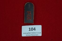 Day Badge, a pressed card badge in the form of a shoulder strap, black and red, bearing the