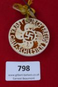 Kraft durch Freude Badge, a circular ceramic badge in brown and cream glaze, depicting a swastika