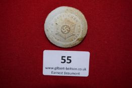 Police Day Badge, 1934, a circular plaster badge with impressed swastika and starburst design,