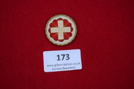 Commemorative Badge, 1939, a circular gilt and enamel badge with white cross on red petal design,