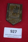Schlitz Heimatfest Tinnie, a pressed-bronze shield-shaped badge depicting townscape, inscribed