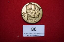 Sudeten Day Badge, 1937, a circular gilt badge depicting two male heads in profile, swastika to
