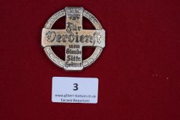 St. Sebastianus Merit Cross Badge, a silvered cross-shaped badge, inscribed in Gothic script Für