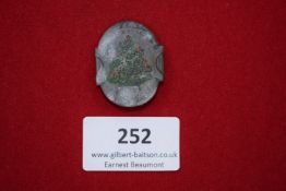 Christmas Commemorative Badge, oval grey metal badge decorated with painted Christmas tree motif,