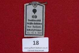 Kaiserliche Schutztruppe Jubilee Badge, 1939, a printed card badge with metal pin, inscribed 69