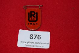 RAD Youth Tinnie, a red enamelled pressed-tin badge dated 1934, with bold black RJ a.d. lettering,