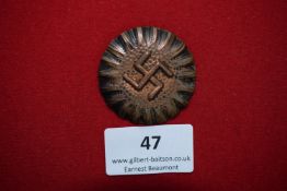 Swastika Sunburst Badge, a circular bronze badge with radiating sunburst and central swastika.