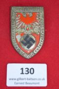 A Third Reich NSDAP rally badge, shield-shaped alloy issue with red enamelled eagle, swastika, and