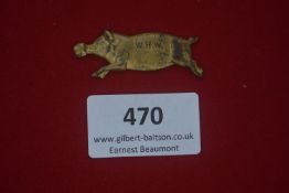A German WWII WHW pressed-metal day badge, gilt finish in the form of a running pig, reverse stamped