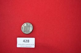 Pressed Metal May Day Badge – A circular pressed brass badge, featuring a central motif of three