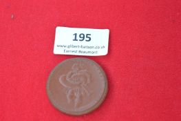 Large brown ceramic commemorative medal, one side with portrait of a child carrying pretzel, reverse