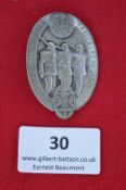 A German Frontsoldaten rally badge, oval silvered alloy issue depicting three marching soldiers with