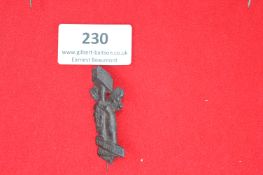 Cast metal stickpin depicting a muscular arm holding a hammer, with oak leaf decoration and motto
