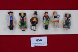 A German WWII WHW set of porcelain figures in regional folk costume, six painted examples. Mounted