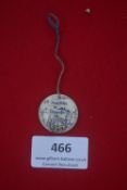 A German WWII WHW porcelain day badge, circular with string suspension, decorated with map design