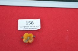 A German Bakelite flower badge, similar to Lot 157, but in yellow-orange plastic carved in floral