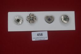 Group of four German WWII metal floral badges — Varied designs including poppy, clover leaf, and