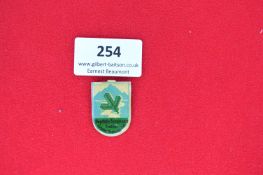 Enamelled Commemorative Tinnie Badge “Deutsche Bergwacht” – A shield-shaped pressed tin badge with