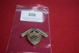 Pressed Metal Commemorative Badge – Shield-shaped badge with central swastika motif on red