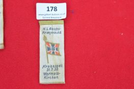 NS-Reichskriegerbund printed cloth day badge, with black-red-white flag and swastika. Text: “