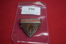 Arbeitsdienst Shield Badge – A shield-shaped pressed metal badge with spade and wheat sheaf motif,