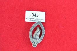 Pressed Metal Shooting Festival Badge – An oval pressed metal badge with raised flaming torch motif,